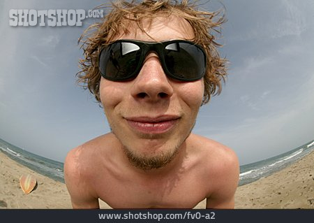 
                Junger Mann, Sonnenbrille, Strandurlaub                   