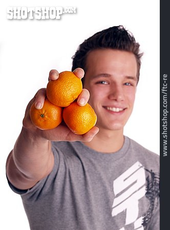 
                Junger Mann, Gesunde Ernährung, Mandarine                   