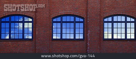 
                Rundbogenfenster, Backsteinfassade, Wolkenspiegelung                   