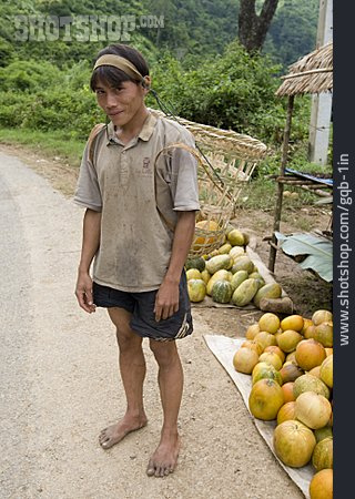
                Junger Mann, Laos, Miao, Gemüseverkauf                   