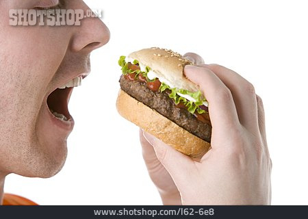
                Junger Mann, Fastfood, Hamburger                   