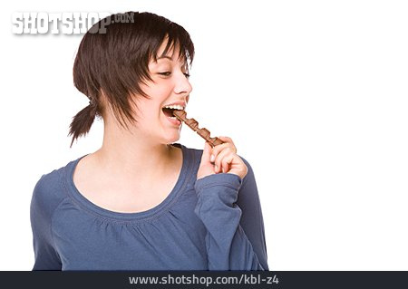
                Junge Frau, Naschen, Schokoladenriegel, Abbeißen                   