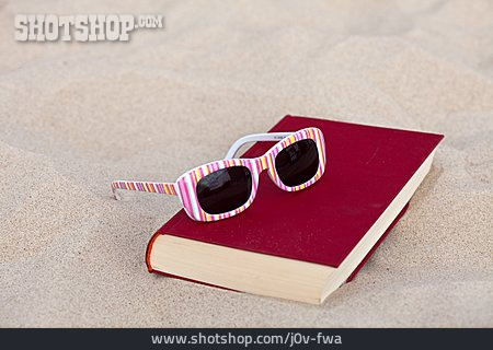 
                Sonnenbrille, Buch, Reiselektüre                   