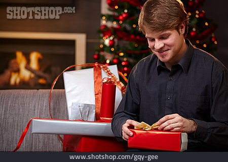 
                Junger Mann, Geschenkverpackung, Verpacken, Weihnachtsvorbereitung                   