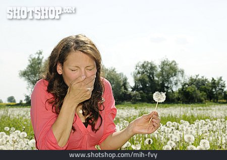
                Junge Frau, Blumenwiese, Niesen, Pollenallergie                   
