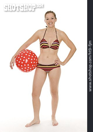 
                Junge Frau, Wasserball, Strandurlaub                   