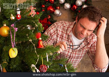 
                Mann, Lichterkette, Weihnachtsbaum                   