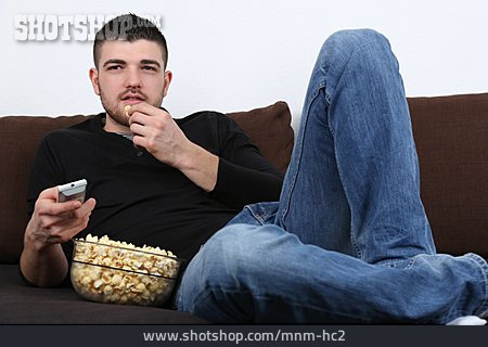 
                Junger Mann, Fernsehen, Popcorn                   