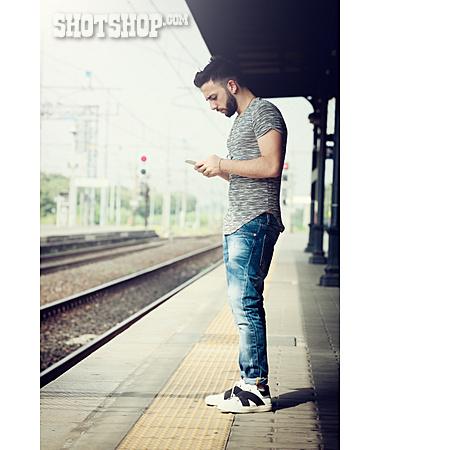 
                Junger Mann, Warten, Bahngleis, Smartphone                   