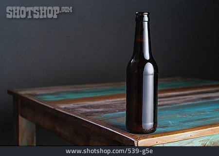 
                Holztisch, Bierflasche                   