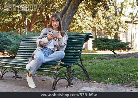 
                Junge Frau, Park, Lesen, Mobil, Smartphone, Datennutzung                   