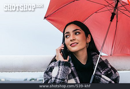 
                Junge Frau, Spaziergang, Telefonieren, Regenschirm                   