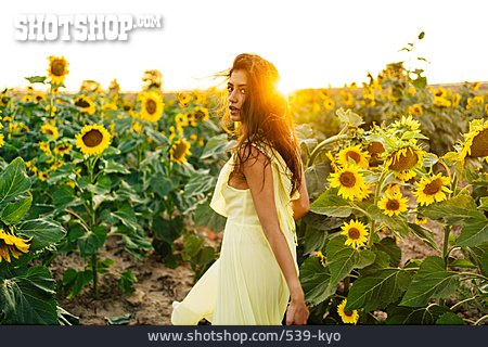 
                Junge Frau, Sonnenblumenfeld, Schulterblick                   