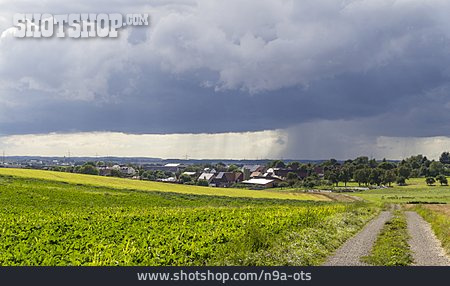 
                Dorf, Regenwolken, Felder                   
