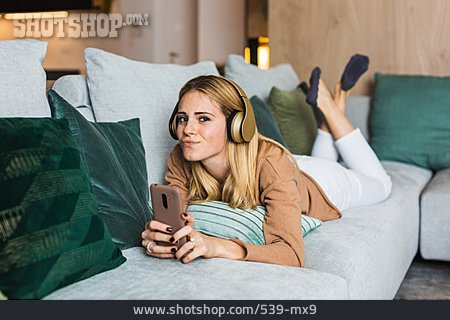 
                Young Woman, Smiling, Home, Lying, Relaxed, Listening Music                   