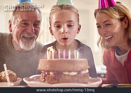 
                Kerzen, Großeltern, Auspusten, Geburtstagskuchen, Enkeltochter, Partyhütchen                   