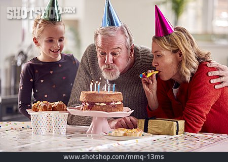 
                Großvater, Kerzen, Auspusten, Geburtstagskuchen, Enkeltochter, Partyhütchen                   