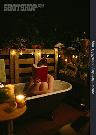 
                Junge Frau, Sommer, Lesen, Badewanne, Kerzenlicht, Lichterkette, Terrasse                   