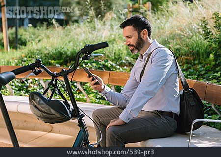 
                Geschäftsmann, Fahrrad, Sitzen, Pause, Lesen, Smartphone                   