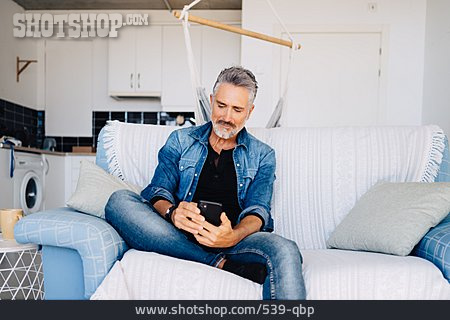 
                Mann, Zuhause, Lesen, Sofa, Smartphone                   