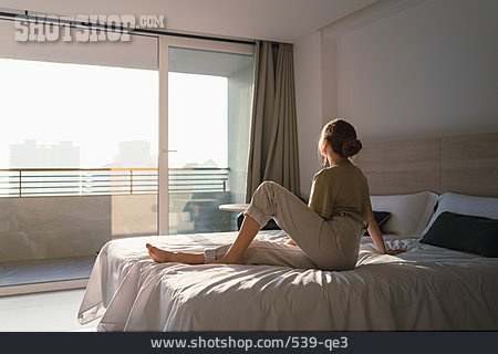 
                Junge Frau, Sitzen, Bett, Rückenansicht, Hotelzimmer                   