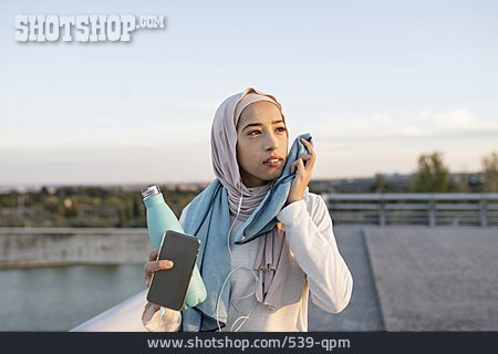 
                Unterwegs, Wasserflasche, Smartphone, Muslima                   