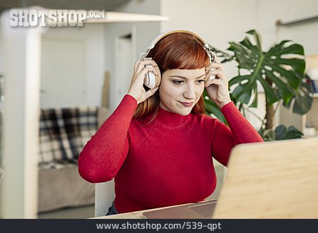 
                Junge Frau, Laptop, Kopfhörer, Schreibtisch                   